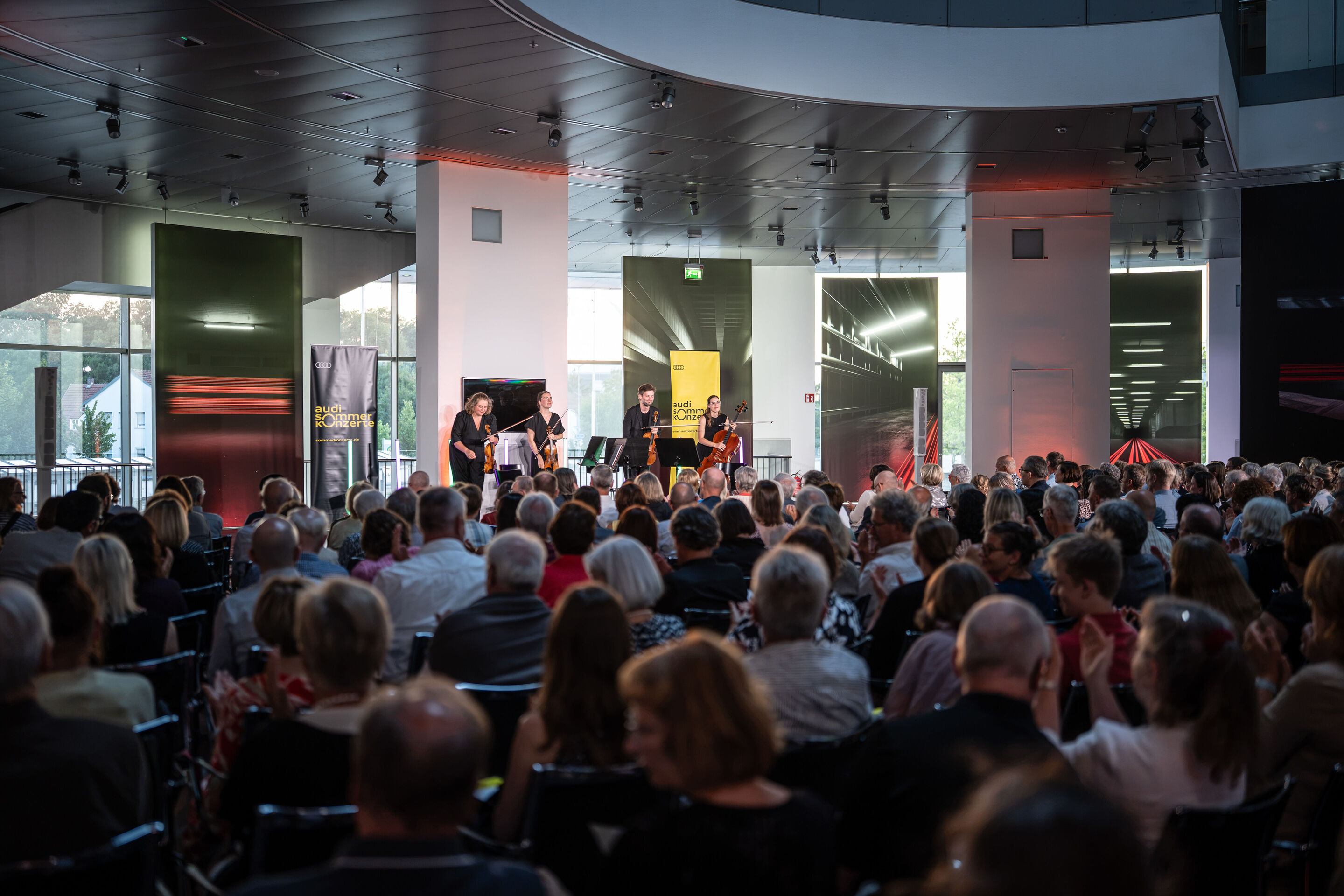 Audi Summer concert: Barbican Quartet at Audi museum mobile - View from the audience of the Barbican Quartet concert at the museum mobile of the Audi Forum Ingolstadt. The four ensemble members stand on stage in front of their music stands while audience...