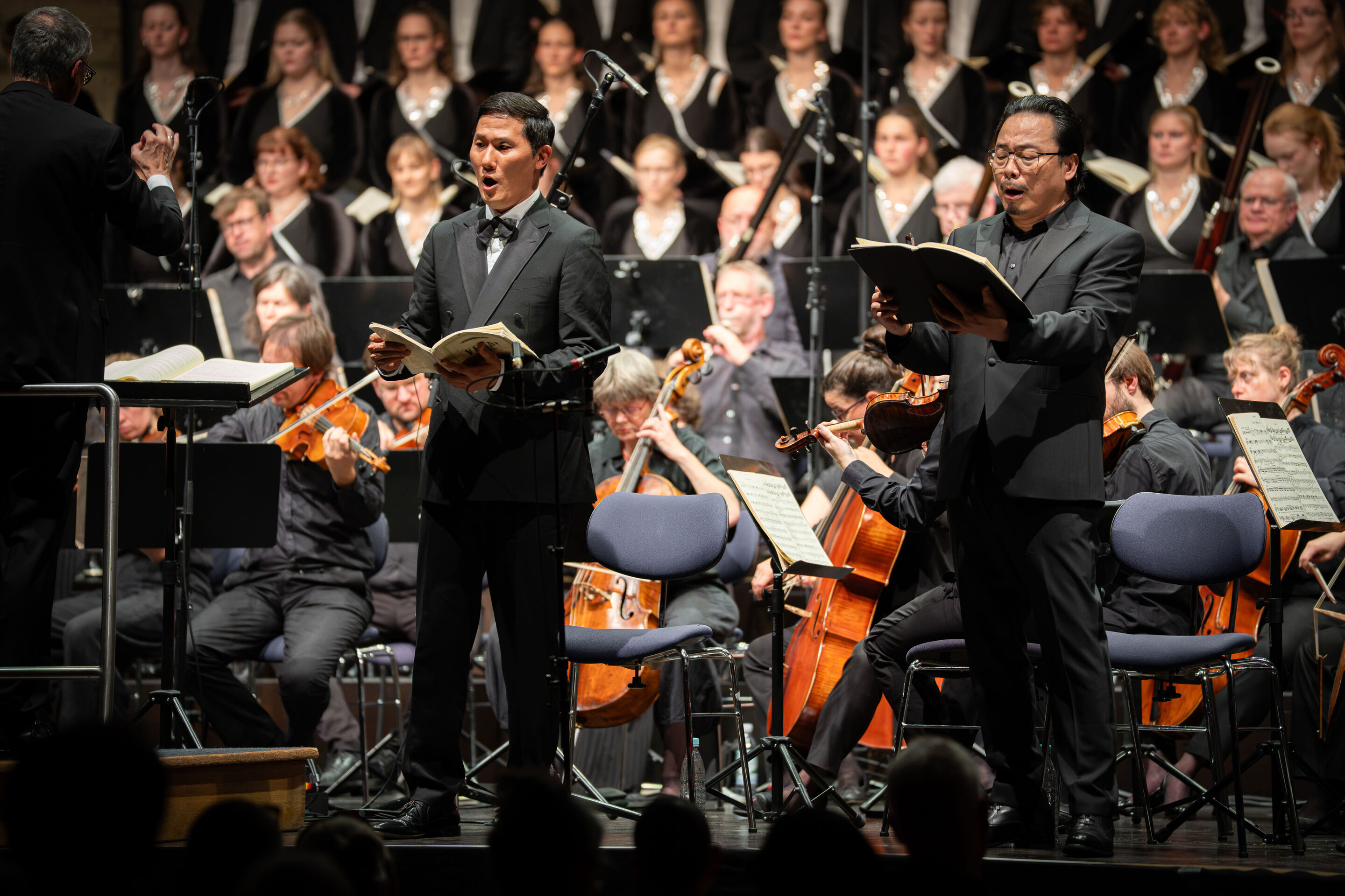 Audi Summer Concerts 2026: Closing concert - View from the audience of the stage in the Festsaal Ingolstadt. Tenor Sung Min Song (left) and bass Liang Li (right) stand in front of the Akademie für Alte Musik Berlin and the Audi Youth Choir Academy, performing...