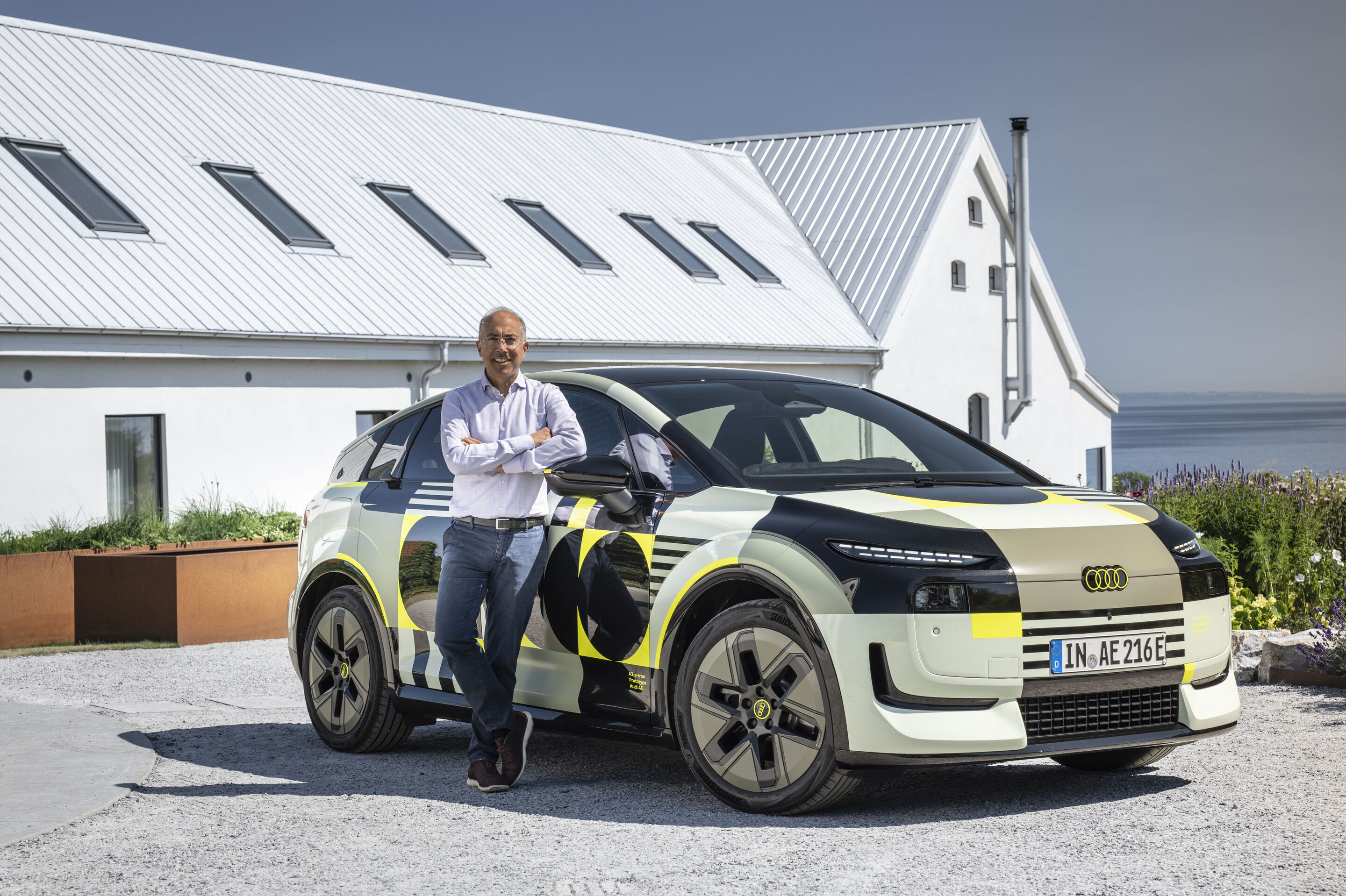 Dr. Moni Islam in front of the Audi A2 e-tron with design livery - Head of Aerodynamics and Aeroacoustics Development at Audi, in front of an Audi A2 e-tron with design livery.