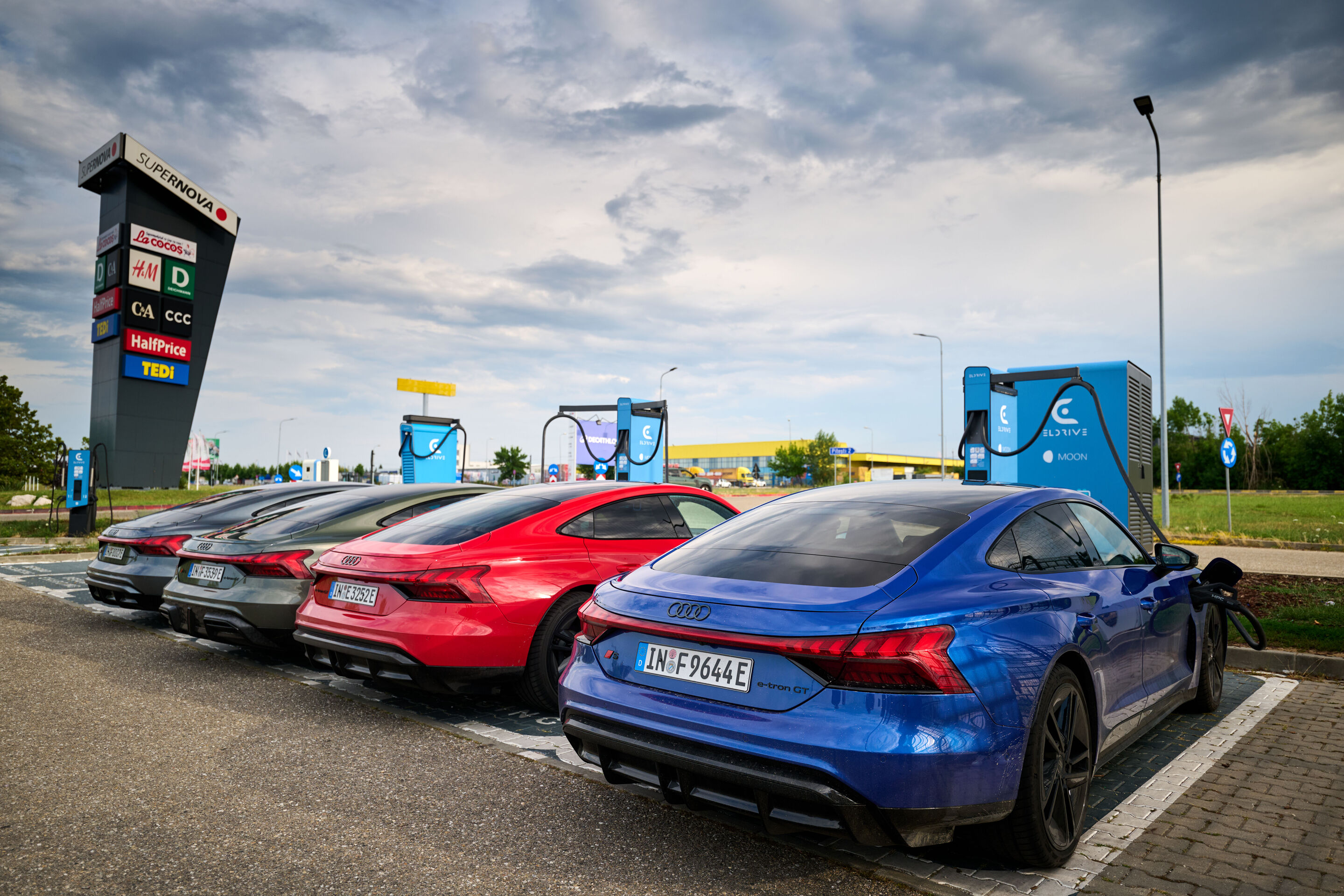 Electric Escape: Through the Carpathians in the Audi e-tron GT - The Audi e-tron GT family at a charging station: High charging power and Romania’s extensive charging infrastructure make recharging on the road a seamless part of the travel experience.