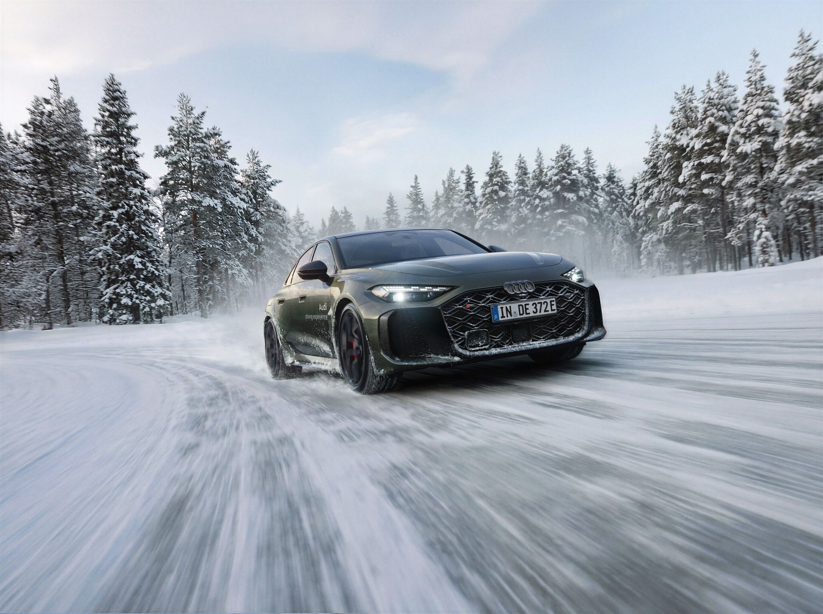 Audi driving experience - Audi RS 5 Limousine in Distriktgrün während der Audi driving experience auf verschneiter Fahrstrecke in Finnland. Outdoor-Fahraufnahme, Exterieur, Dreiviertelfrontansicht.