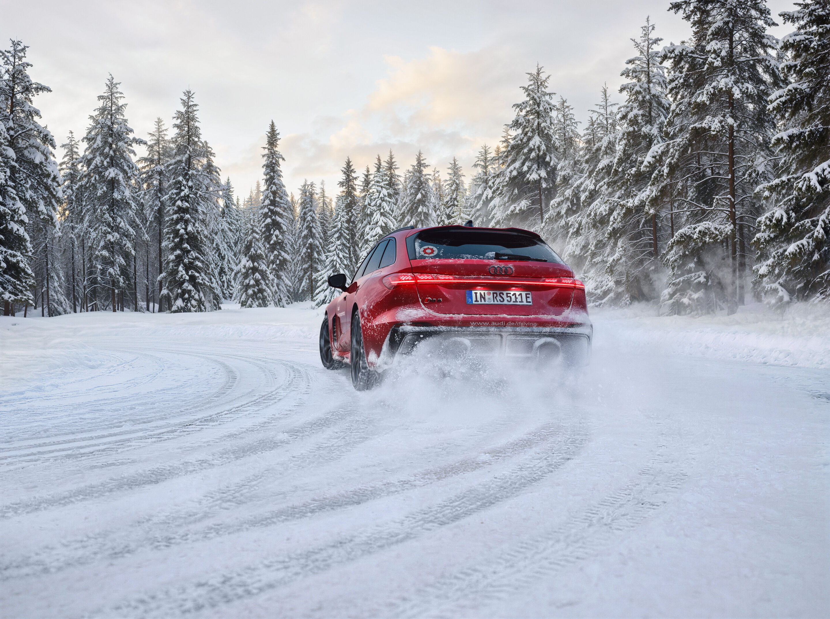 Audi driving experience - Audi RS 5 Avant in Rot, Outdoor-Fahraufnahme, Exterieur, Heckansicht auf verschneiter Strecke in der winterlichen Landschaft Finnlands