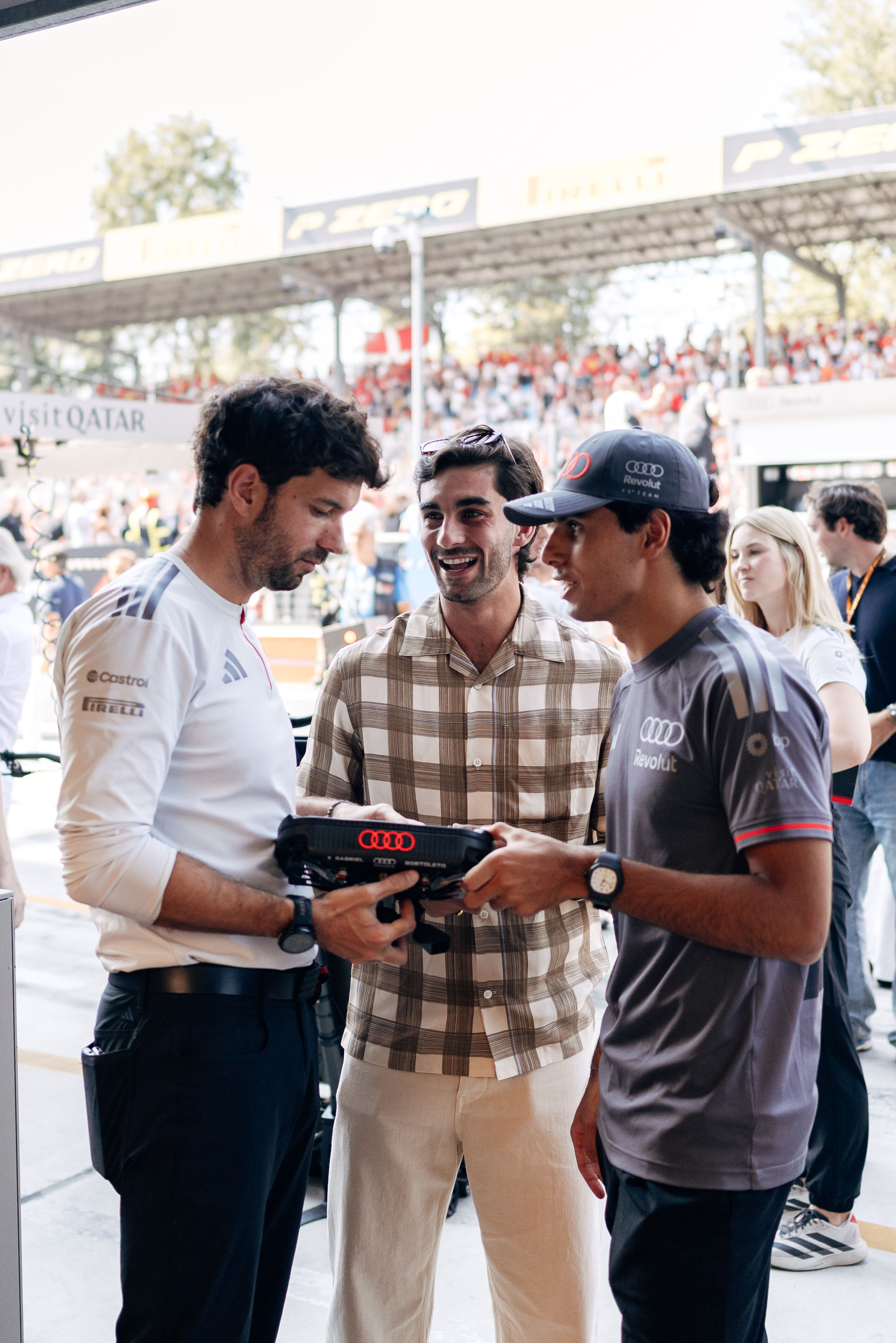 Audi Revolut F1 Team: Grand Prix von Italien - Gabriel Bortoleto und Renningenieur Jose Manuel Lopez erklären Fußballstar Ferran Torres (Paris Saint-Germain) das Lenkrad des Audi R26