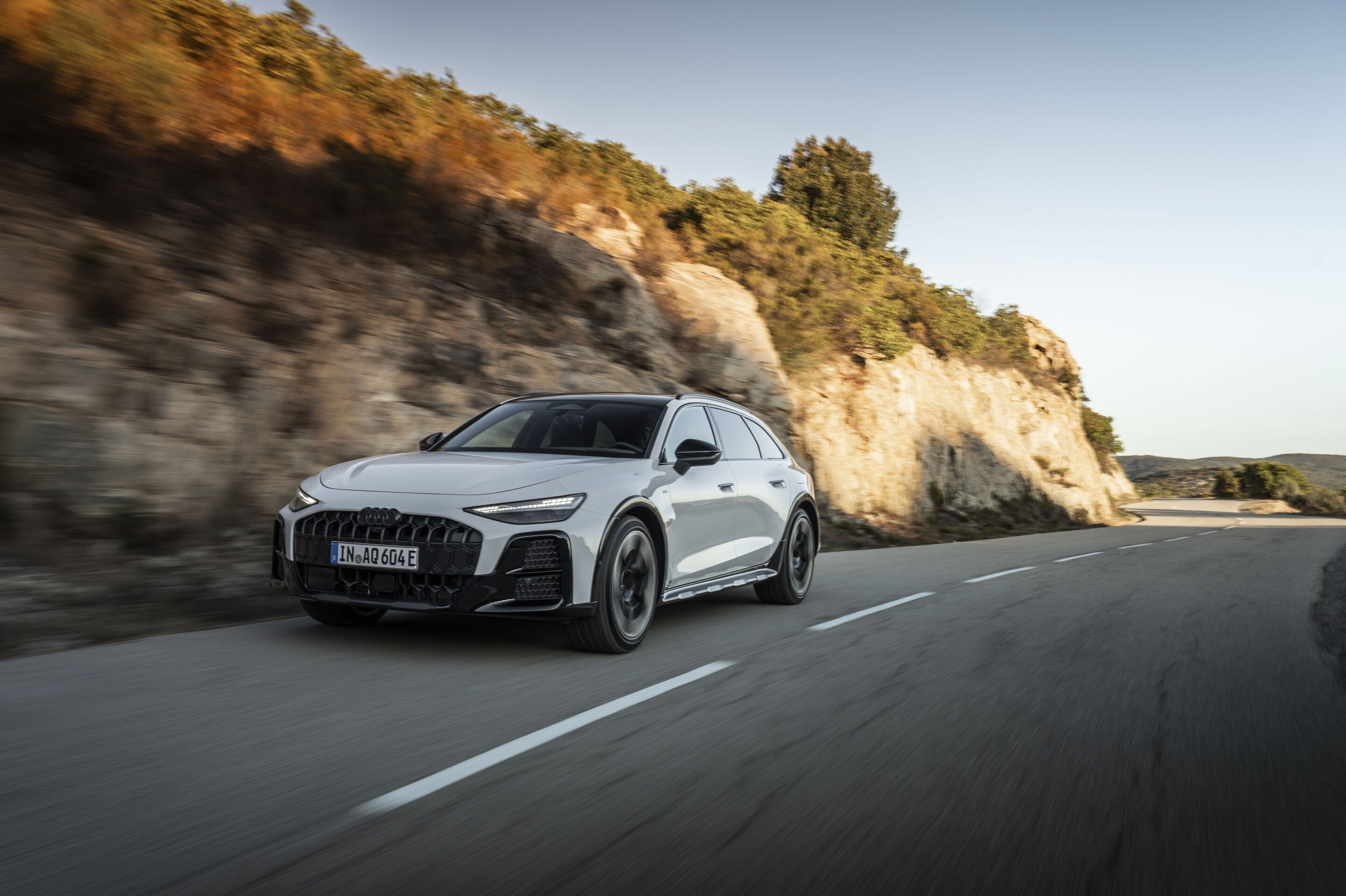 A6 allroad e-hybrid - Audi A6 allroad e-hybrid in Glacier White metallic, outdoor driving shot, exterior, in a mountainous setting.