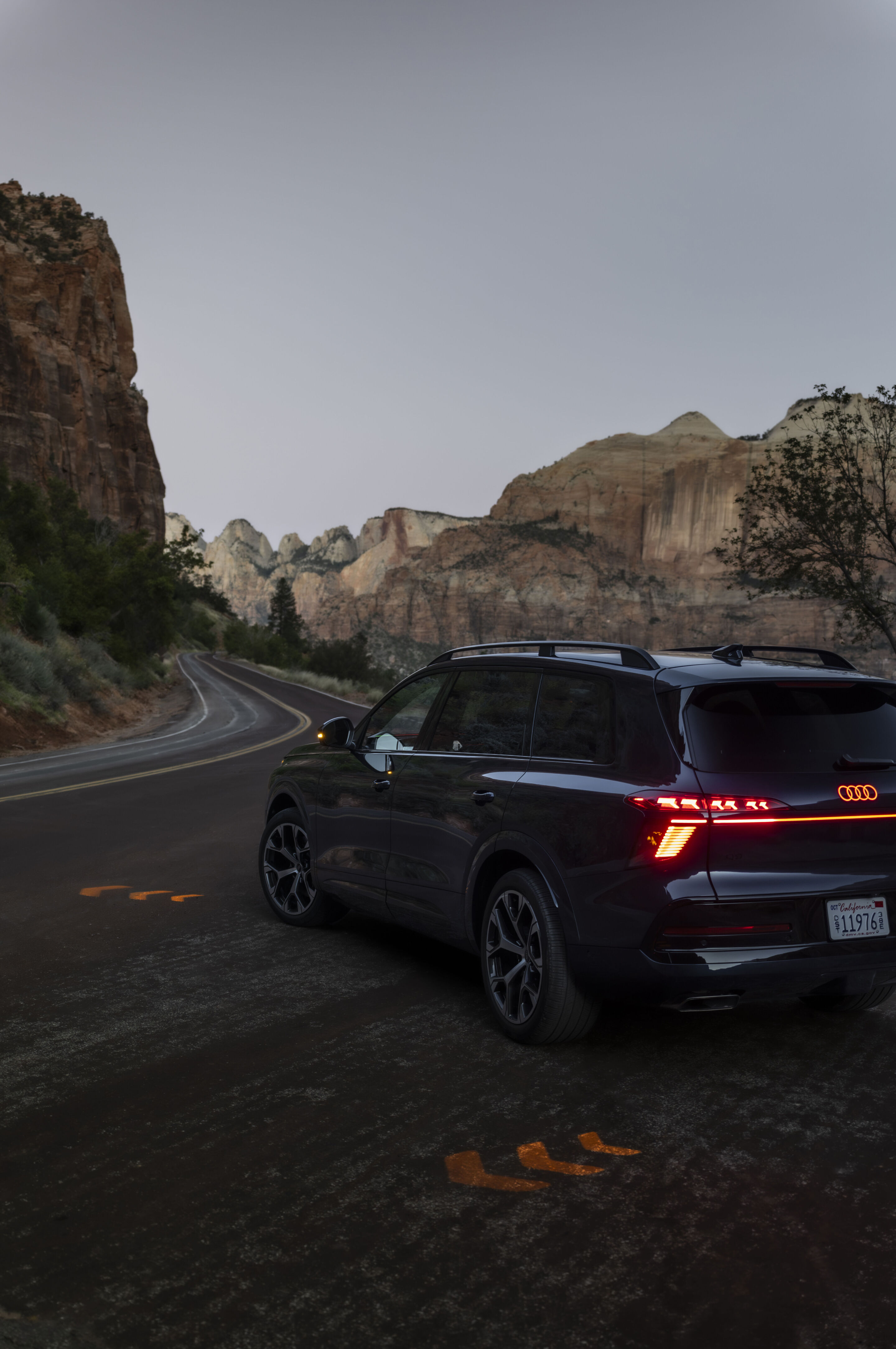 Audi Q9 SUV - Audi Q9 SUV in Waitomoblau Metallic in Utah. Der Audi Q9 ist die neue Spitze des Audi Portfolios. Das erweiterte Blinklicht wird bei Nacht synchron zum dynamischen Blinker in der Front und am Heck auf den Boden abgebildet.