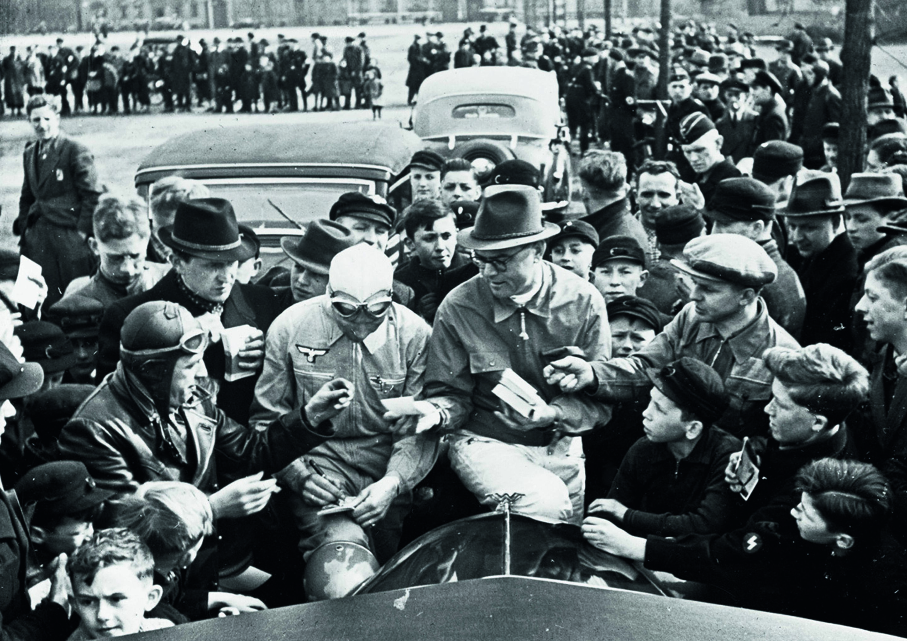 Jubiläumsmagazin Motorsport - Autogrammstunde: Die Fahrer Schorsch Meier und Rudolf Hasse 1939.