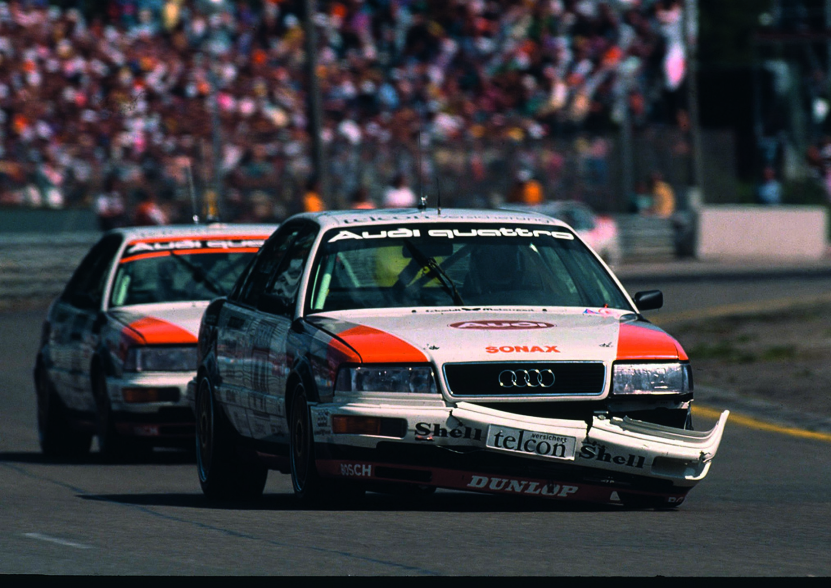 Jubiläumsmagazin Motorsport - Kampfspuren: Stuck mit hängender Frontschürze vor Röhrl 1991 am Norisring.