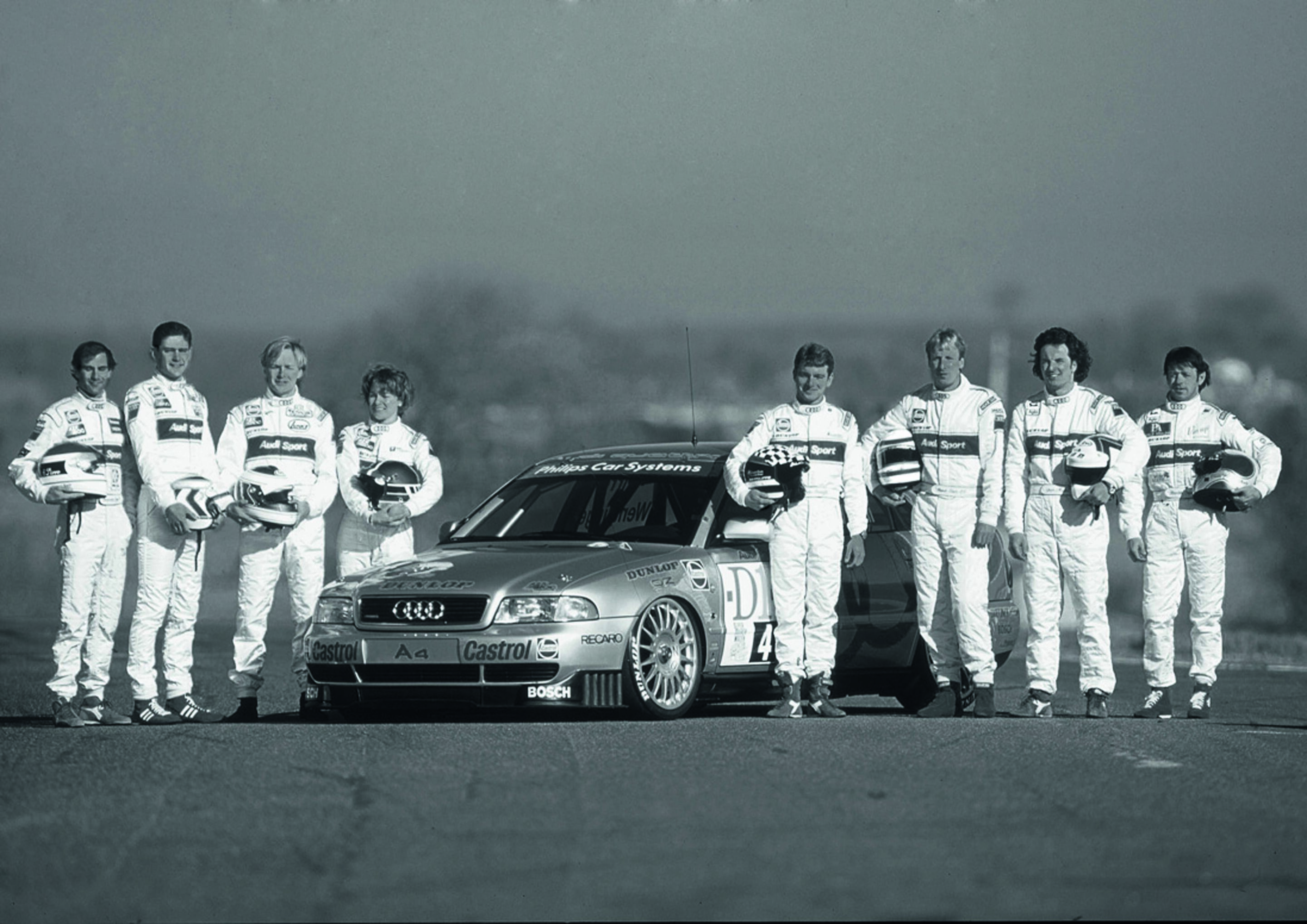Jubiläumsmagazin Motorsport - Gruppenbild mit Dame: Die acht Audi-Werkspiloten - darunter Tamara Vidali - für die Saison 1996.