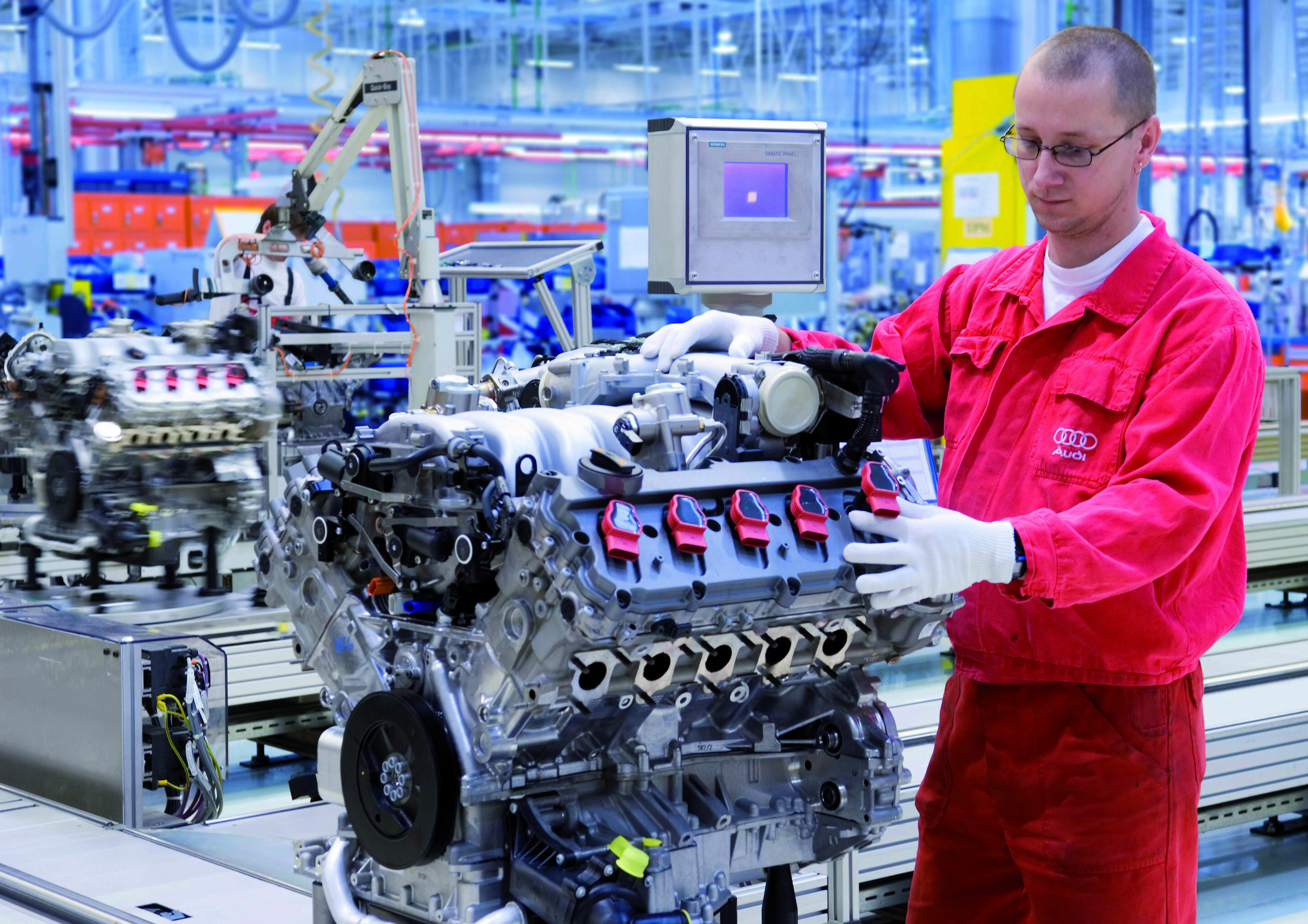 Production of the V10 with FSI technology at AUDI HUNGARIA Motor Kft. in Györ - An employee at the final visual check following mounting of the ignition coils on the V10 engine