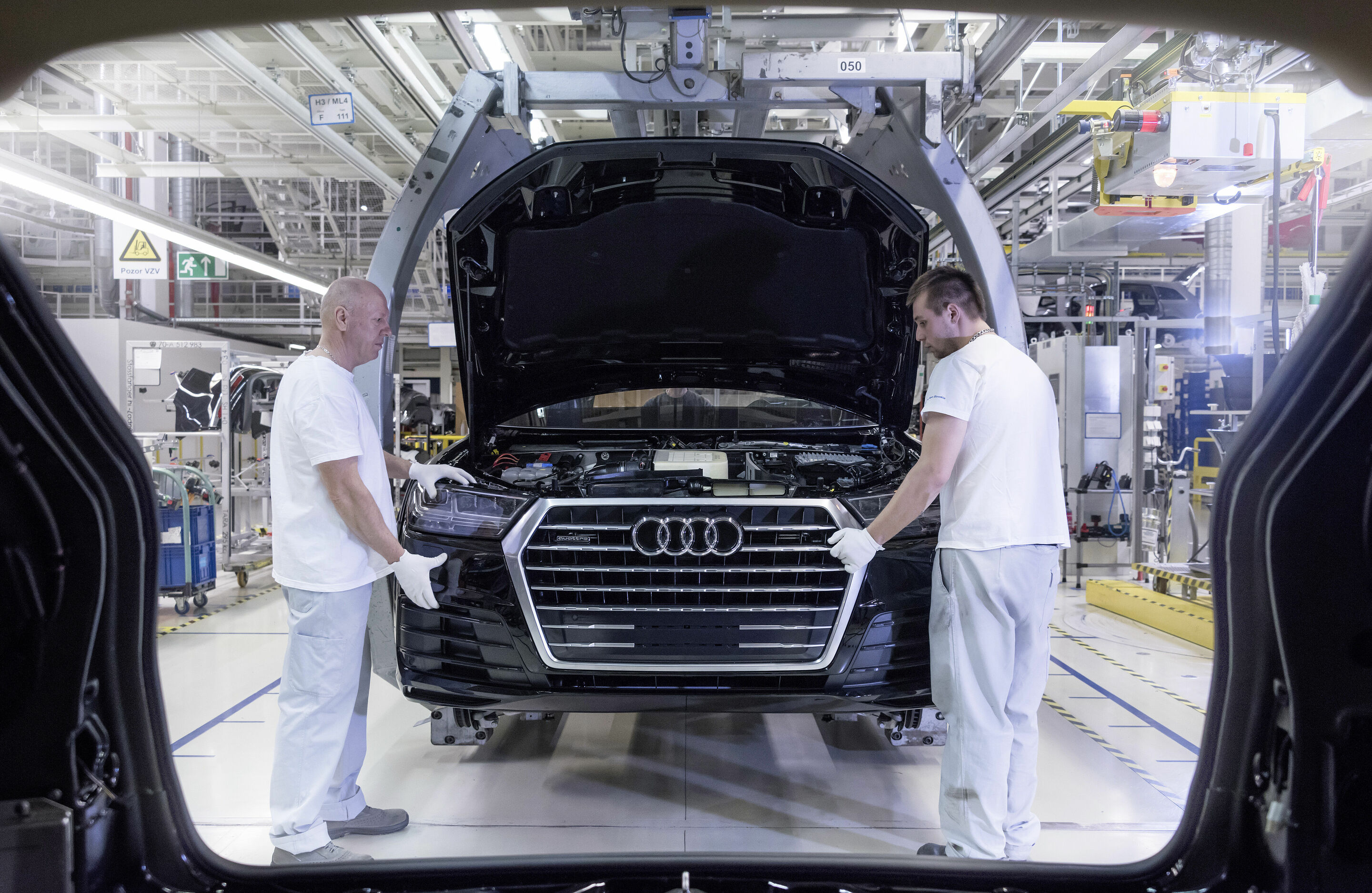 Audi Bratislava - Mitarbeiter bringen den Stoßfänger an einem Audi Q7 an.