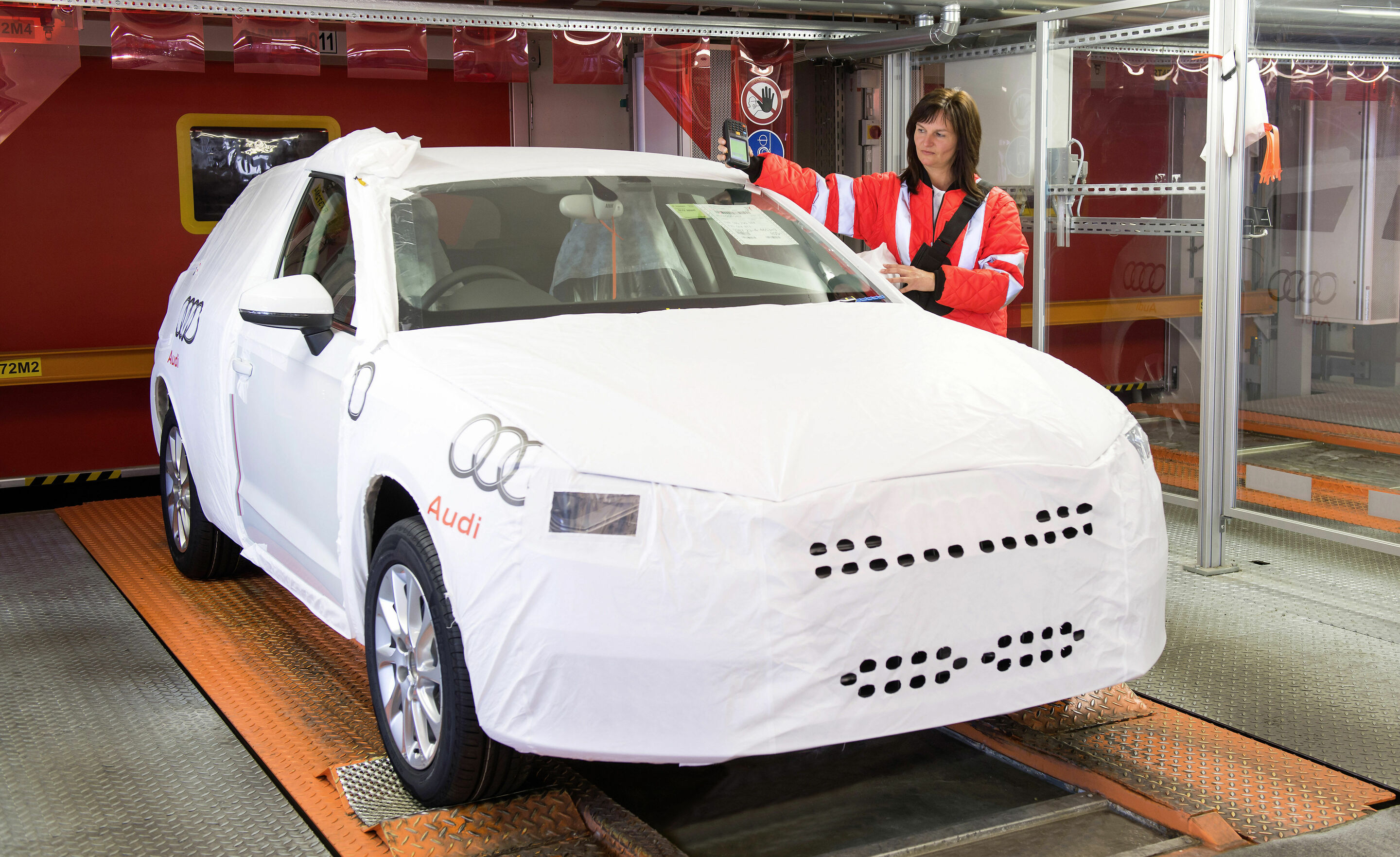 Processing Building at the Audi site Ingolstadt - An Audi employee collects the transport data of each car in the Processing Building using a hand scanner. This tells her where the Audi will be delivered to and when it is going to be loaded onto a train...