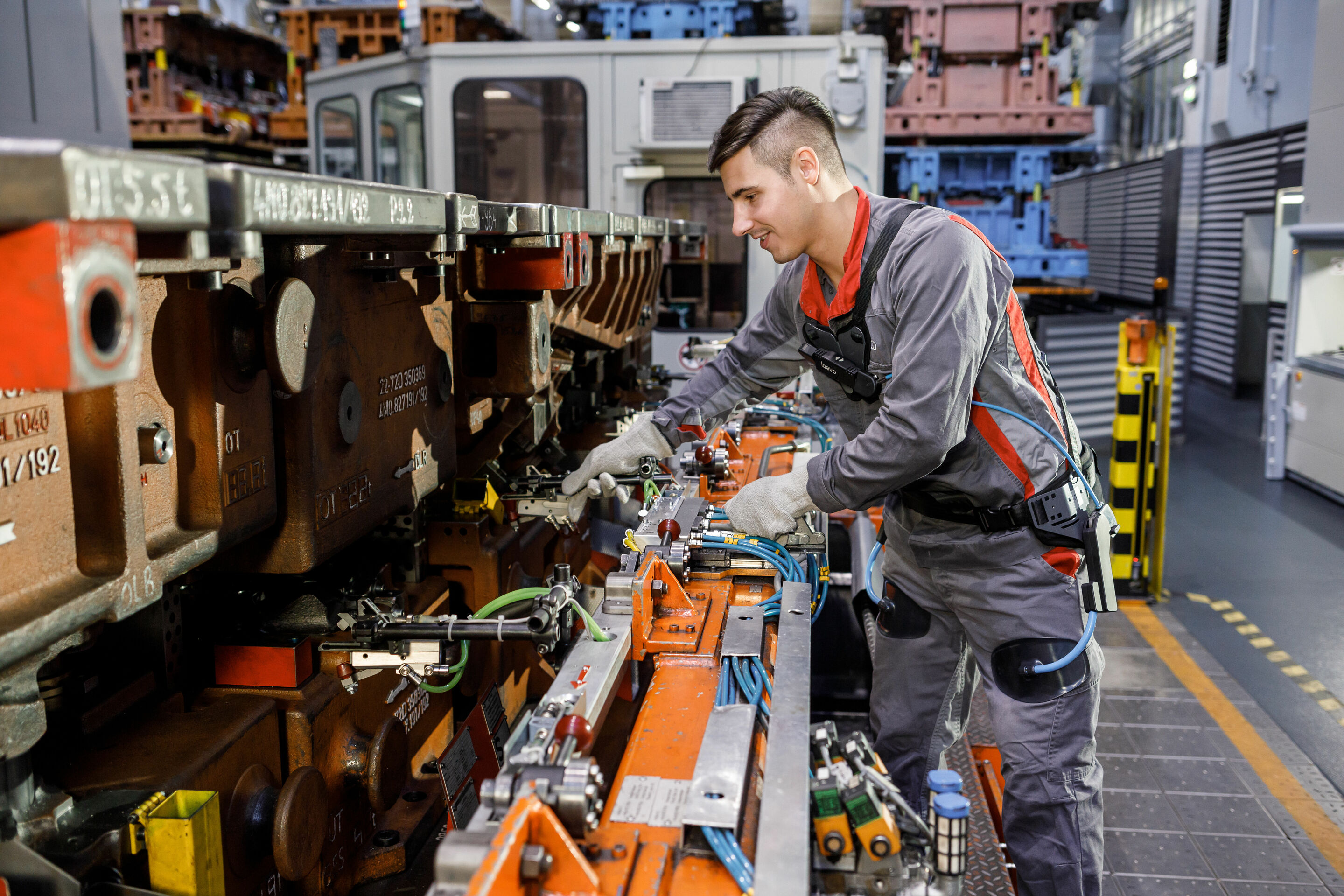 Audi production: working without backache with the exoskeleton - The ergonomic aid supports employees in production and logistics when lifting and carrying heavy materials. When preparing the transfer press, an employee uses the exoskeleton in the press...