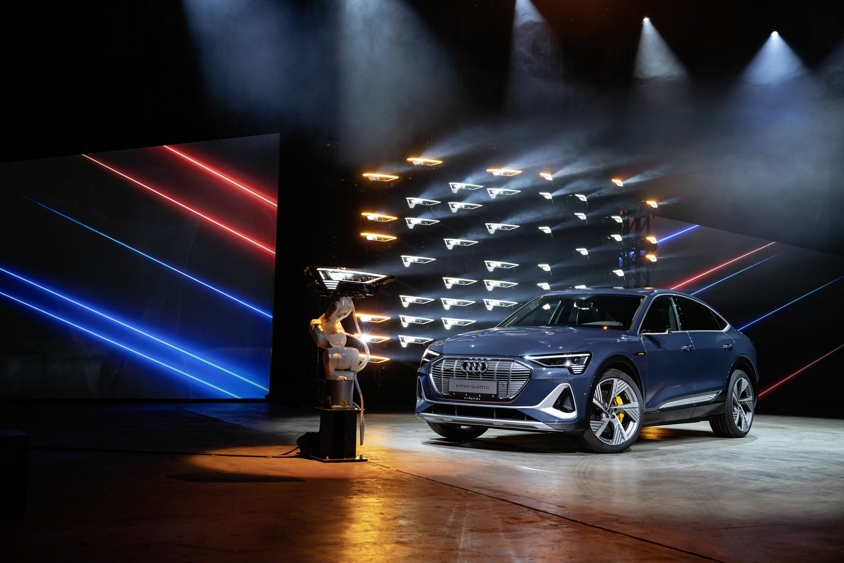 Audi e-tron Sportback 55 quattro - Standaufnahme,
Farbe: Plasmablau 
„Das abgebildete Fahrzeug zeigt Sonderausstattungen gegen Mehrpreis. Einzelne Ausstattungen werden erst zu einem späteren Zeitpunkt verfügbar sein.“