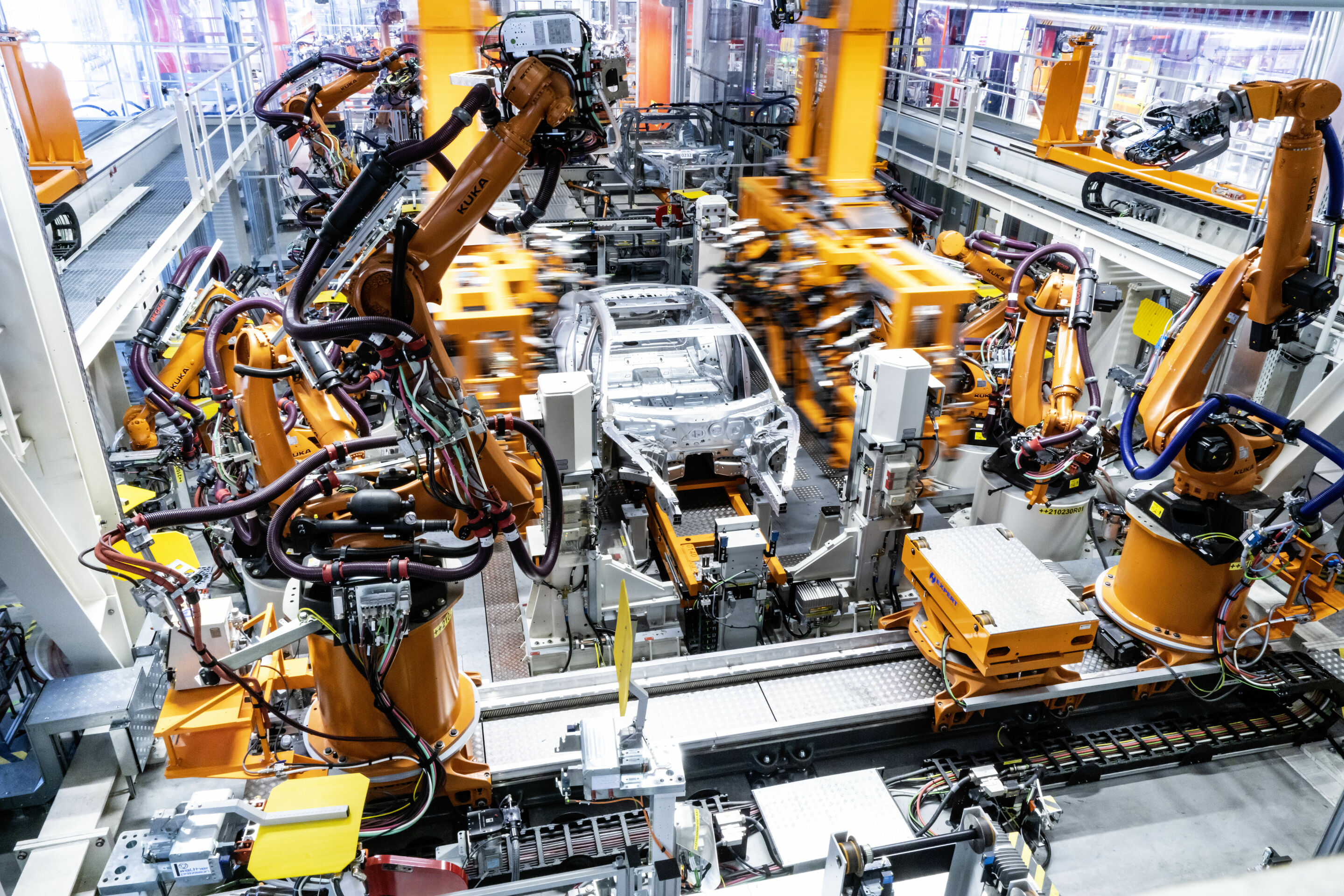 High-tech meets craftsmanship - The body shop of the Audi e-tron GT at Böllinger Höfe: The two-way framer combines all manufacturing steps for joining the sides in single system. The system comprises 10 robots and 32 tools.