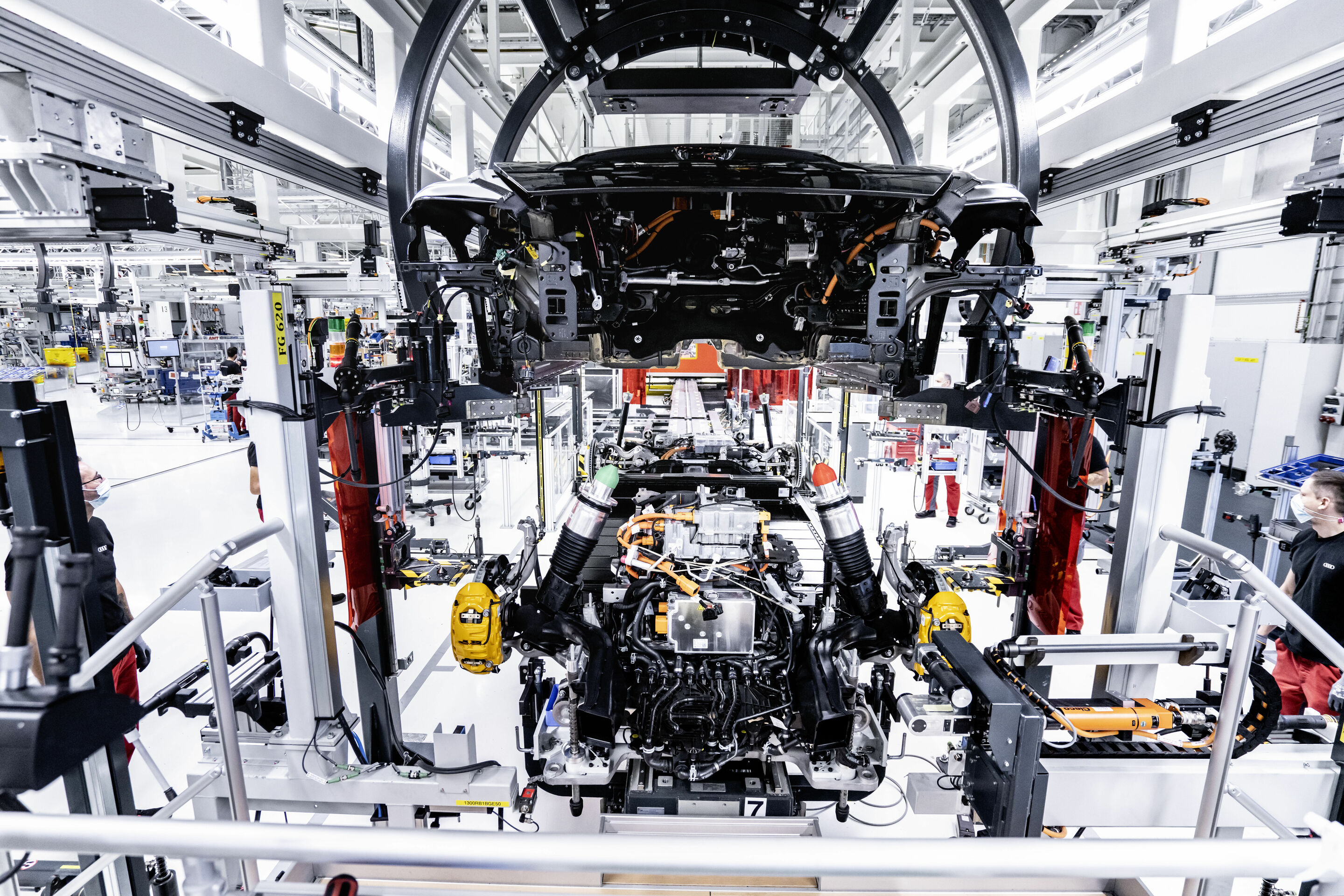 Hightech trifft Handwerkskunst - Montage des Audi e-tron GT in den Böllinger Höfen: Bei der Hochzeit verschrauben Mitarbeiter die Batterie und die Antriebskomponenten an 74 Punkten mit der Karosserie.