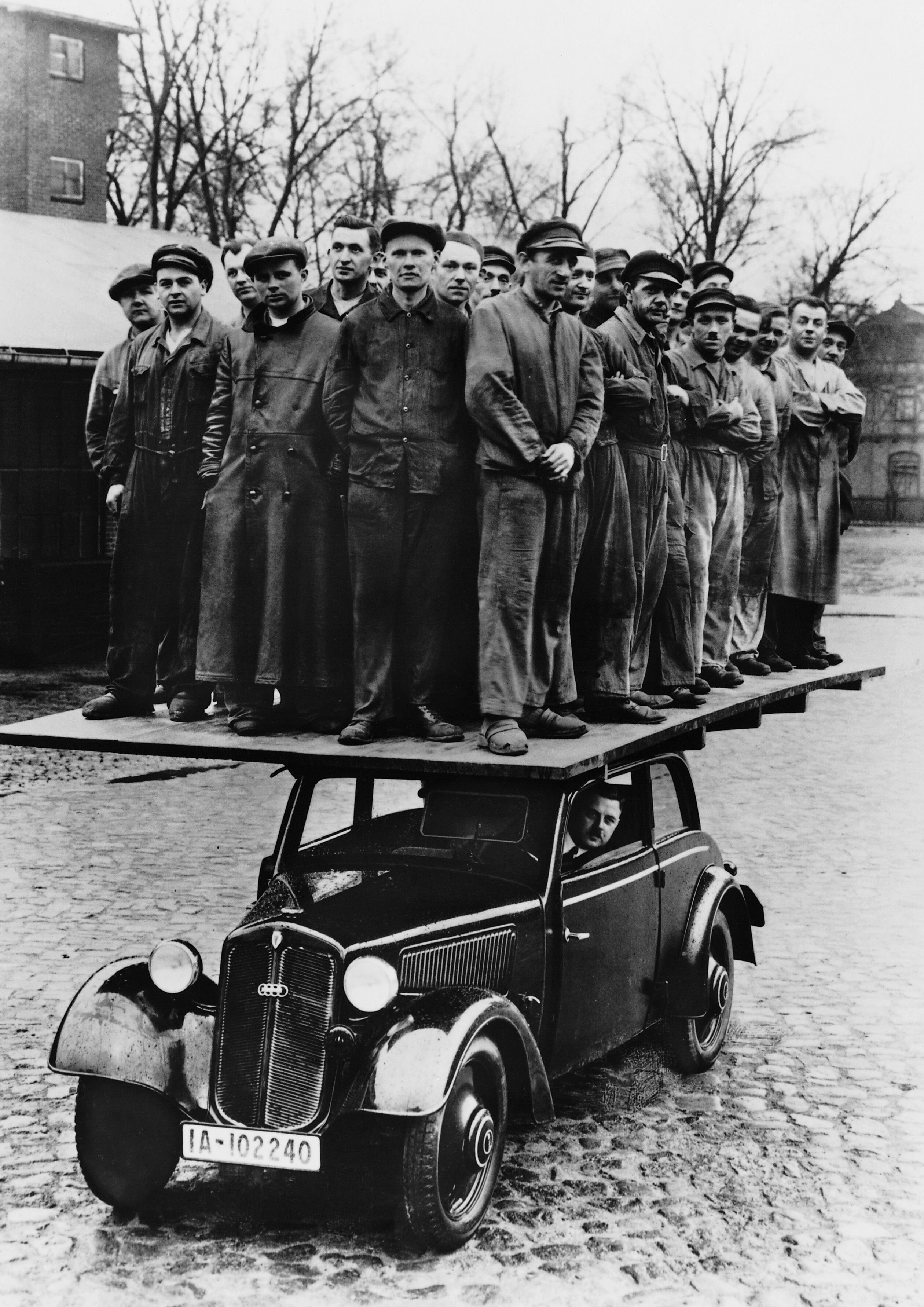 30 Männer auf dem Dach einer DKW-Front Reichsklasse Typ F7. Das Foto diente dazu, die Stabilität der DKW Holzkarossien unter Beweis zu stellen.