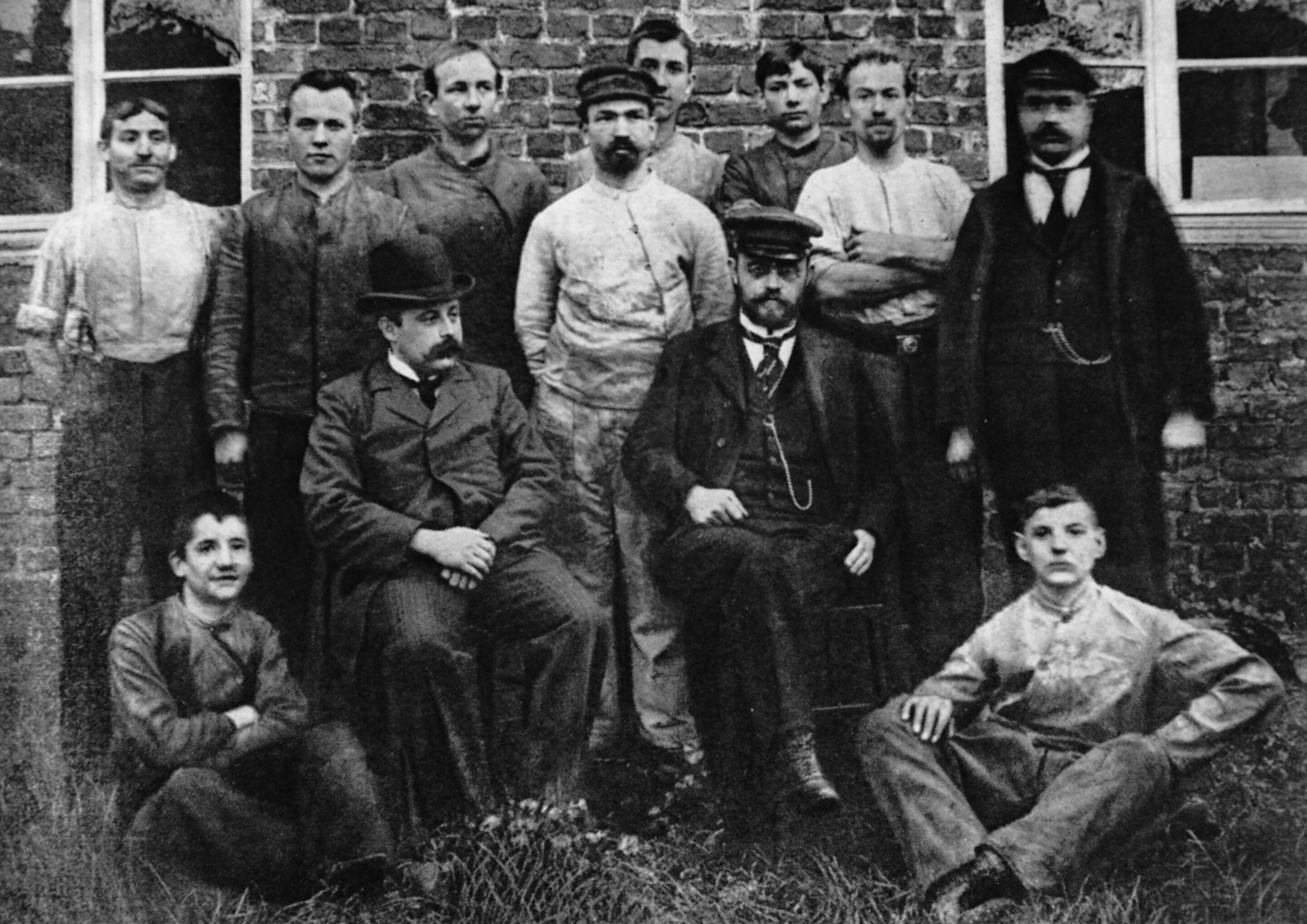August Horch (mit Schirmmütze sitzend) und die erste Belegschaft seiner Motorwagenfabrik in Köln
